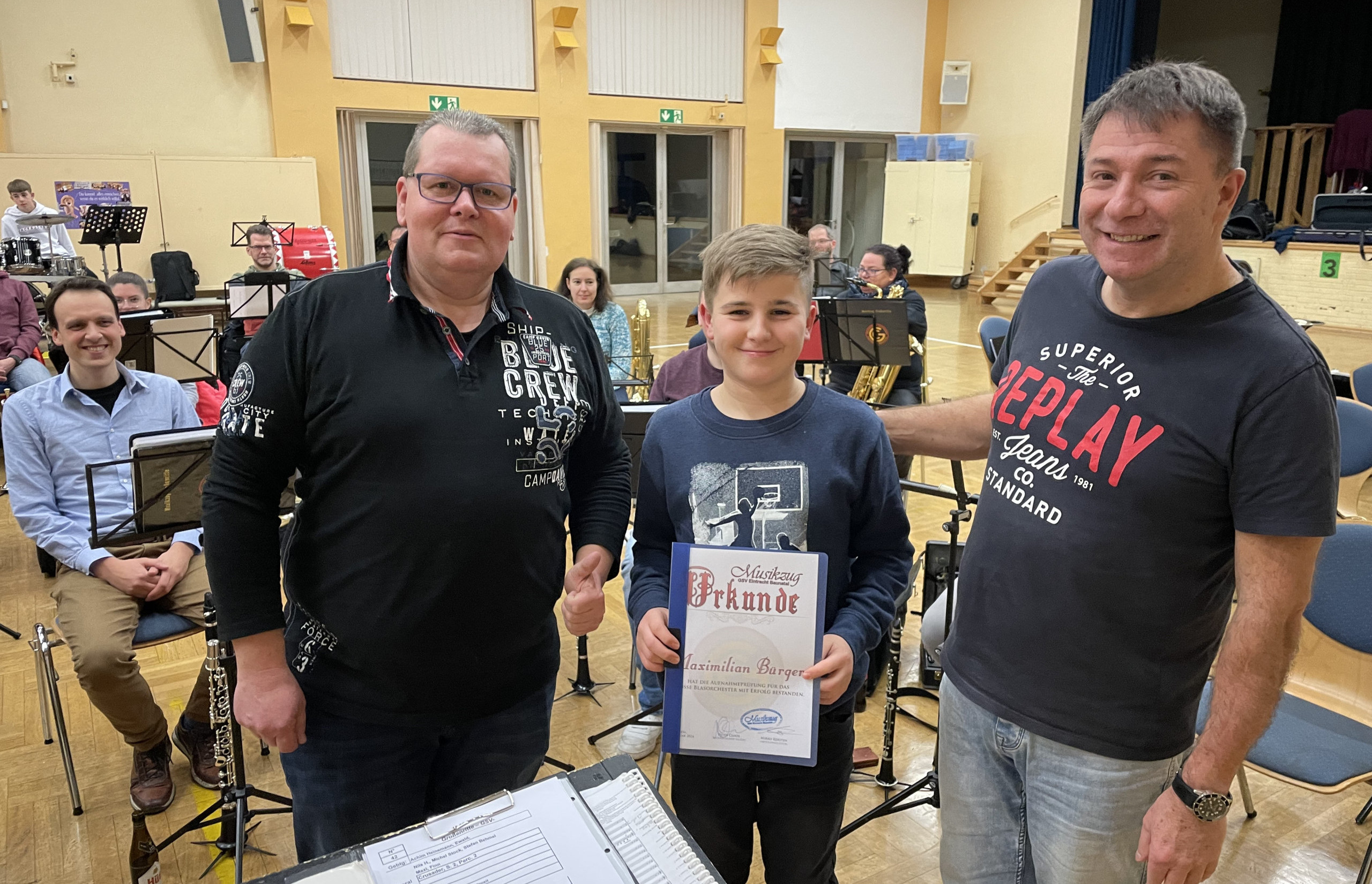 Maximilian Bürger hat die Aufnahmeprüfung für den Musikzug bestanden. Mirko Kersten und Peter Cloos heißen ihn im Musikzug willkommen.