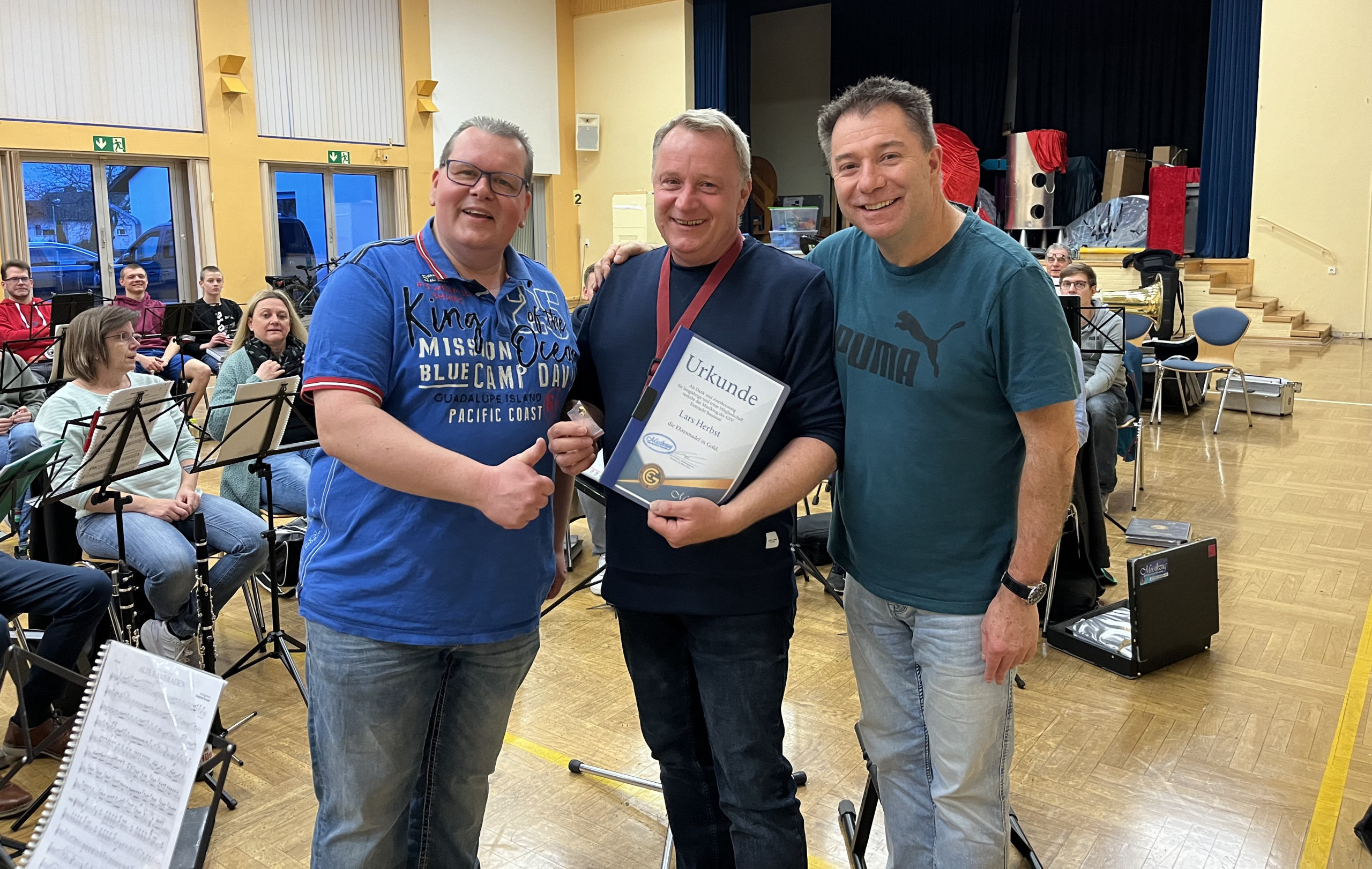 Lars Herbst (Mitte) erhält die Ehrennadel in Gold des GSV-Musikzugs von Abteilungsleiter Mirko Kersten (links) und Dirigent Peter Cloos.