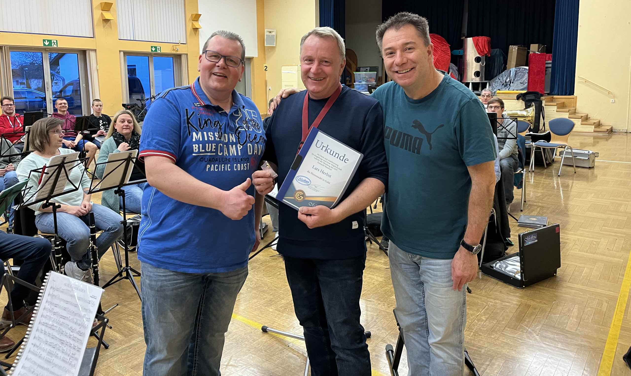 Lars Herbst (Mitte) erhält die Ehrennadel in Gold des GSV-Musikzugs von Abteilungsleiter Mirko Kersten (links) und Dirigent Peter Cloos.